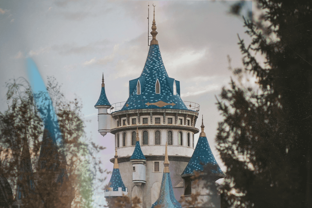 A fairytale castle with blue turrets framed by trees